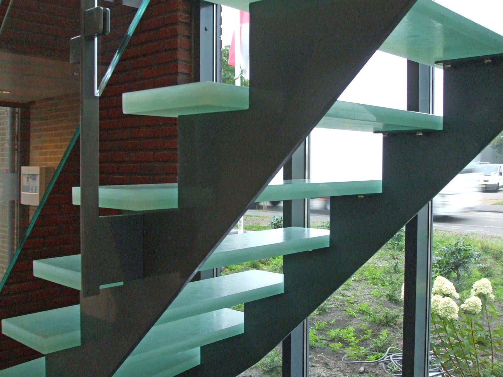 Stalen design trap met traptreden van glas
