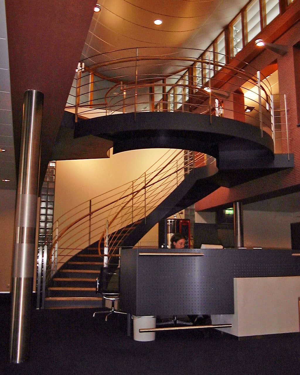Lange brede wenteltrap met luxe houten traptreden